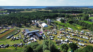 Luftbild vom Außengelände des Agroneum mit Windmühle, 2 Silos und vielen parkenden Autos.